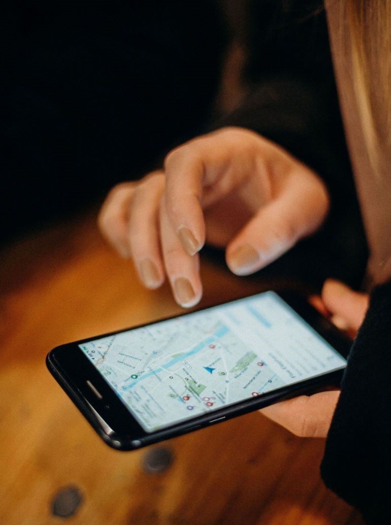A person holding an iPhone with Google Maps on the screen